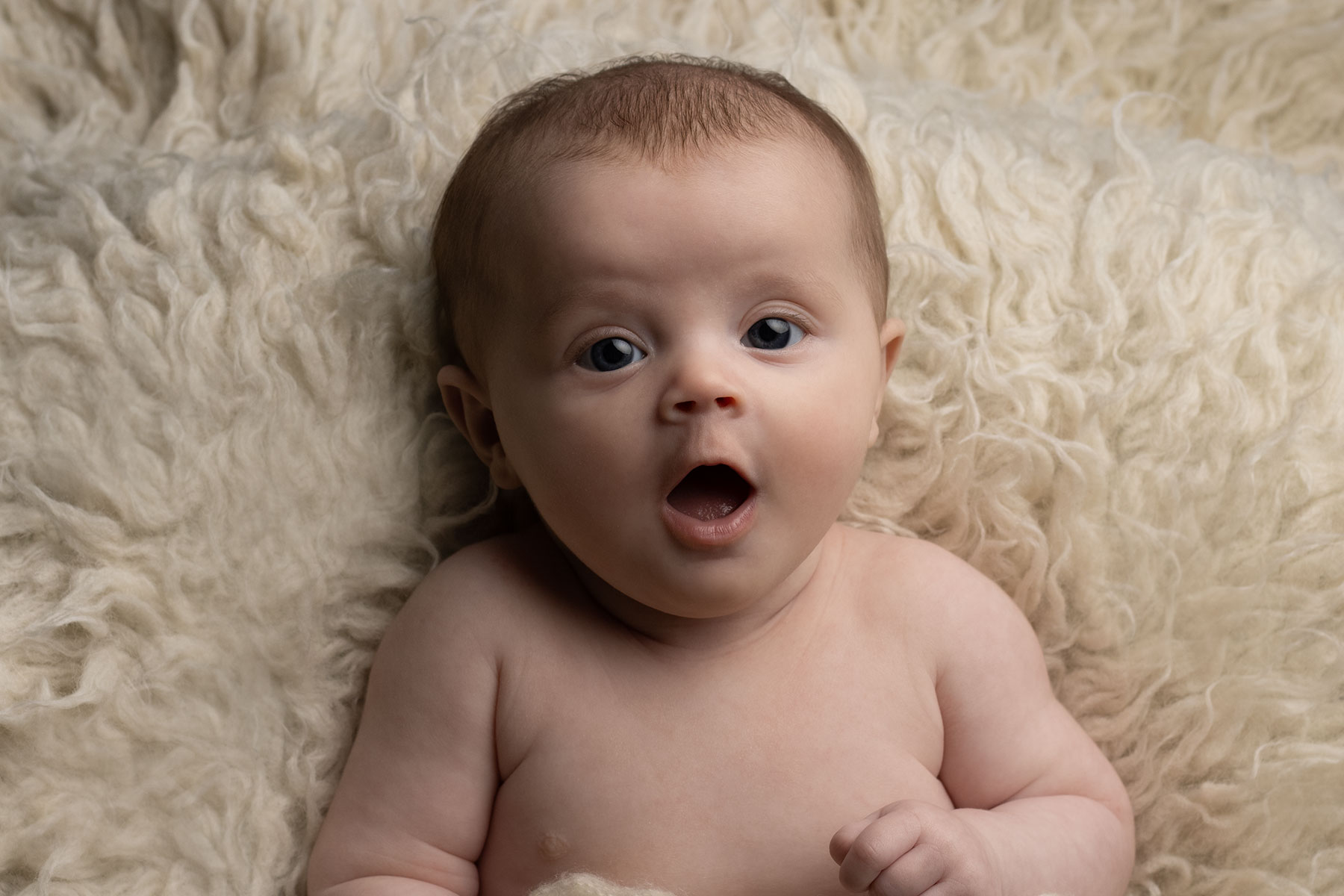 Baby girl looking towards the camera during an at-home newborn session