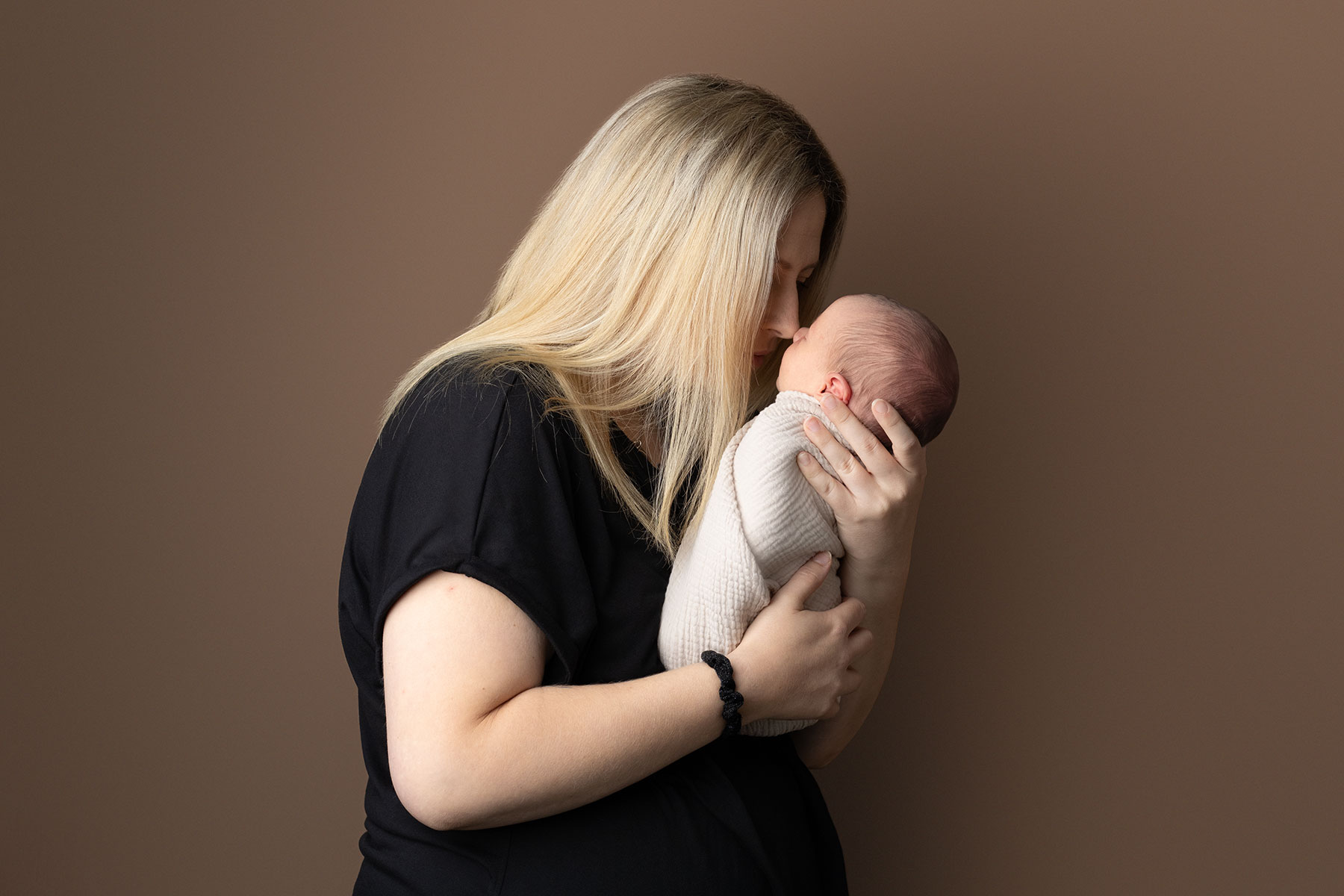 Mother touching noses with her newborn baby
