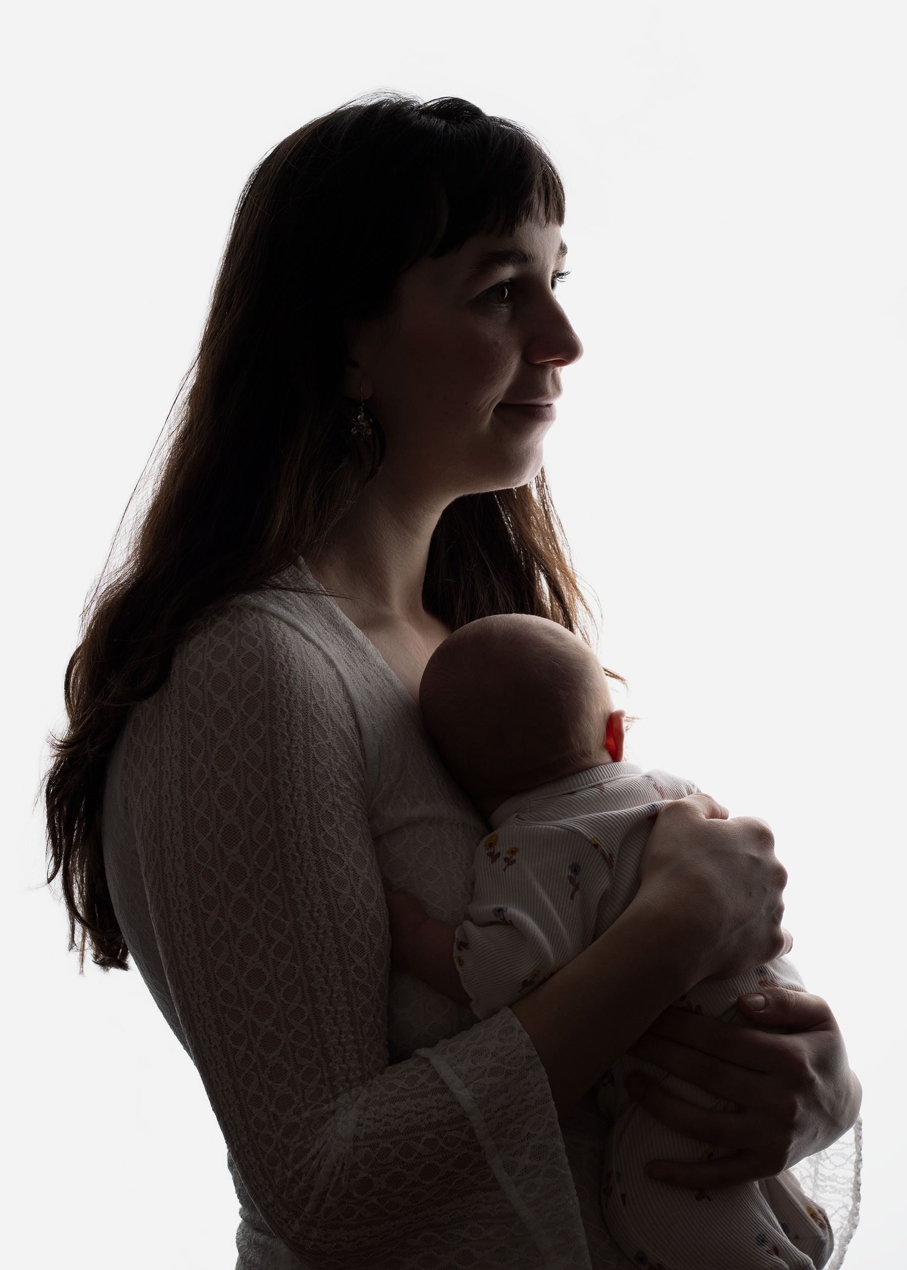 Mother holding her newborn baby during relaxing newborn photoshoot in Ceredigion