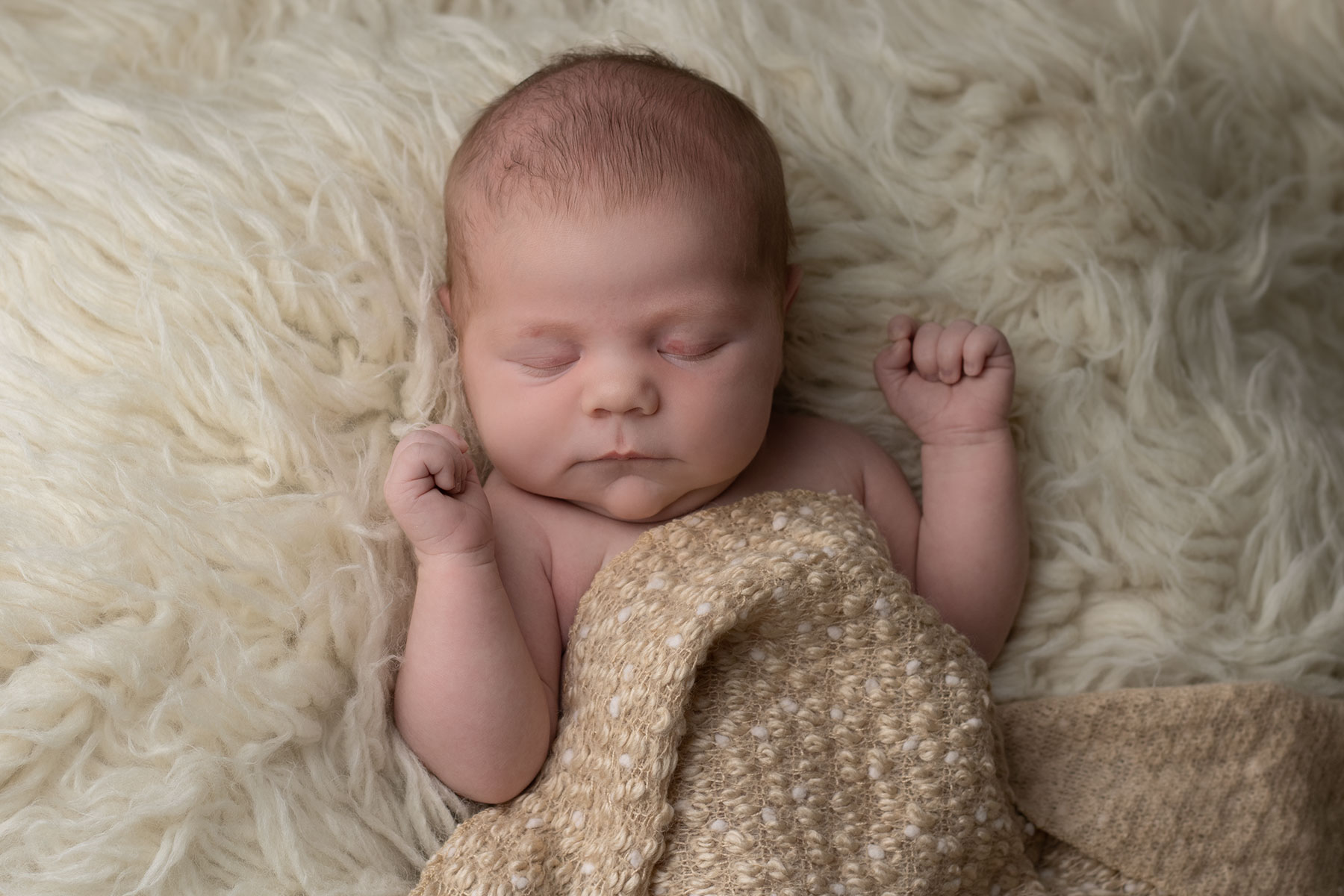 Baby sleeping on a cream blanket with Ceredigion newborn photographer