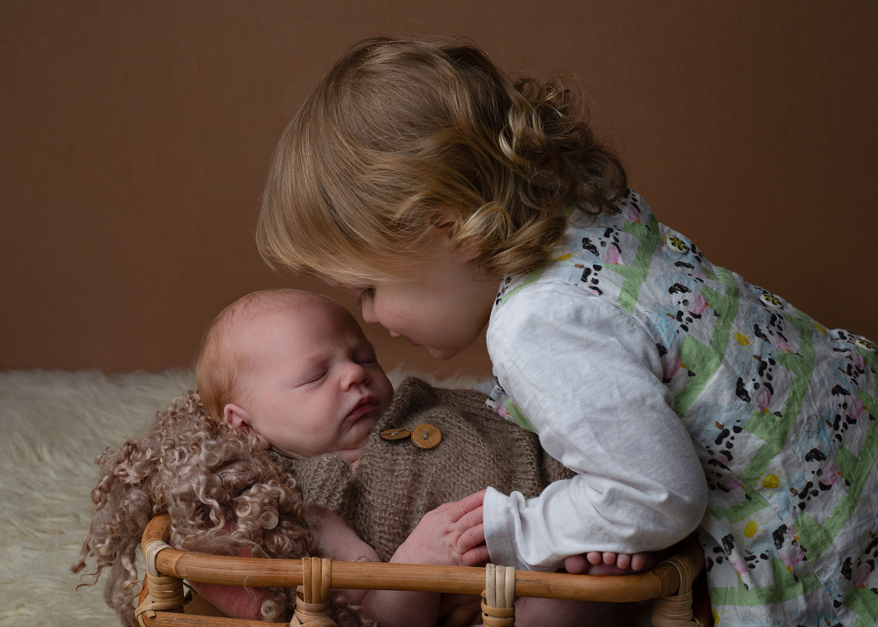 Little girl cuddling her baby brother with Ceredigion newborn photographer
